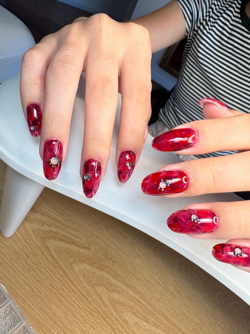 Long red marble nail extensions at Queen Bee Nails Rockingham WA